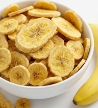 Banana Bites dog treat — size reference with dog paw